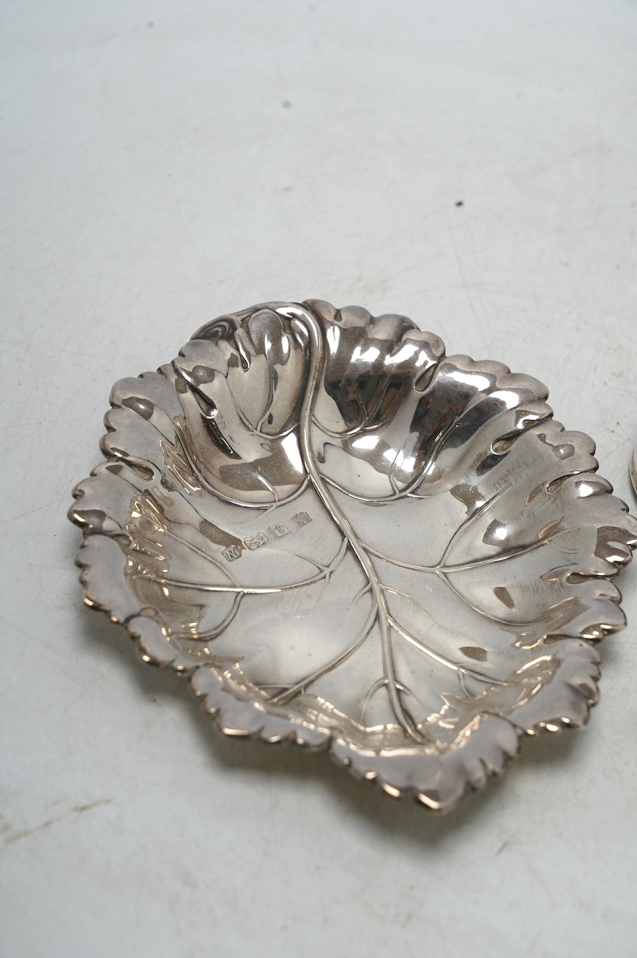 A Victorian silver circular case and cover, containing a collapsible beaker (now detached from the base), by Thomas Johnson I, London, 1873, diameter 53mm, together with a silver napkin ring and modern silver leaf dish.